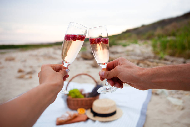 Two glasses of champagne. Picnic on the beach at sunset in the w - Foto, imagen