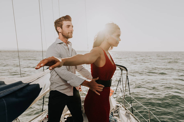 happy couple taking a romantic cruise on the sail boat - Photo, image