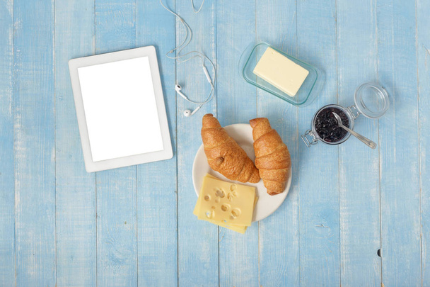 White tablet in home kitchen with croissants, jam, cheese, butter and coffee, top view. Breakfast table concept - Foto, afbeelding