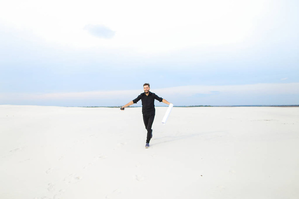quimico macho con smartphone saltando de alegría en pla desierto
 - Foto, Imagen