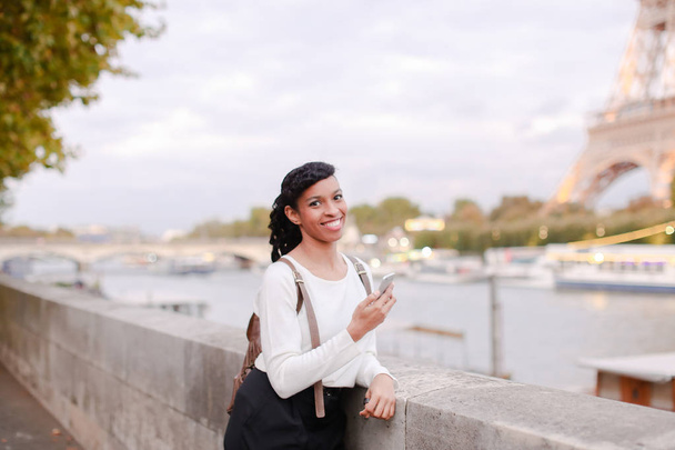 Smiling business woman standing on bridge and using smartphone - Foto, afbeelding