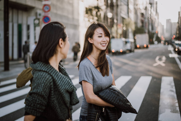 Two japanese women around in Tokyo during daytime. Making shoppi - Zdjęcie, obraz