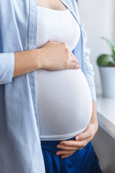 primer plano mujer embarazada tocando su vientre
 - Foto, Imagen