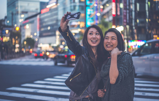 Two japanese women around in Tokyo during daytime. Making shoppi - Foto, afbeelding