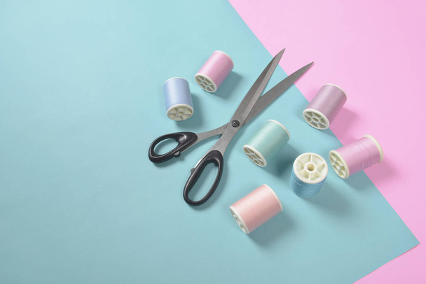 Flat lay of colored thread rolls and Scissors for sewing on two  - Foto, Imagem