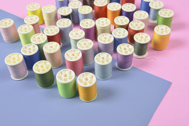 Flat lay of colored thread rolls for sewing on two tone backgrou - Fotoğraf, Görsel