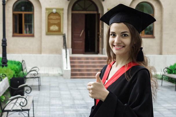 Woman portrait on her graduation day. thumbs up. University. Education, graduation and people concept. - Photo, Image
