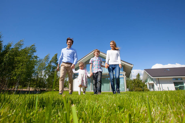 Family walking on lawn near house - Photo, image