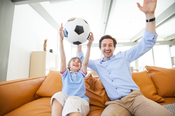 Boy watching soccer match with father - Photo, image