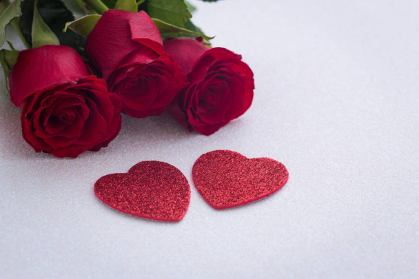 περιστασιακή όμορφα κόκκινα τριαντάφυλλα με διακοσμητική καρδιά και ένα μέρος για αφιερώσεις ή επιθυμίες - Φωτογραφία, εικόνα