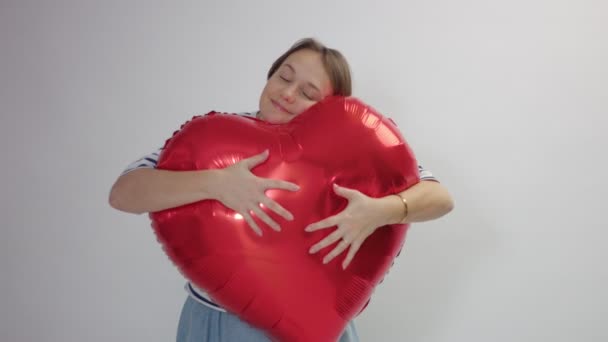 kaukázusi nő hugs egy hatalmas piros szív, és tartsa - Felvétel, videó