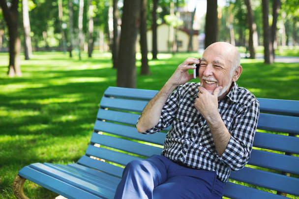 携帯電話屋外で年配の男性 - 写真・画像