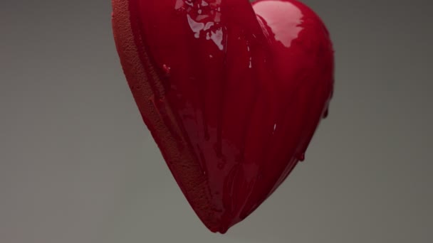 latające czerwone serce mokre w powietrzu z Czerwony przezroczysty płyn pokryte go i wylaniem na nim - Materiał filmowy, wideo