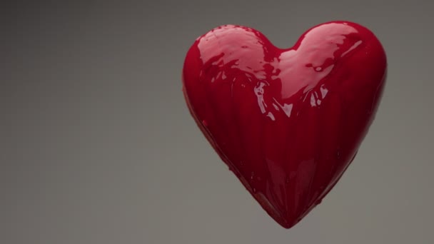 cuore bagnato rosso volante in aria con liquido rosso trasparente coperto e versando su di esso
 - Filmati, video