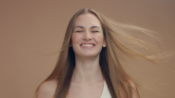 modelo de mulher de beleza no estúdio no fundo bege com vento no cabelo soprando-o
 - Filmagem, Vídeo
