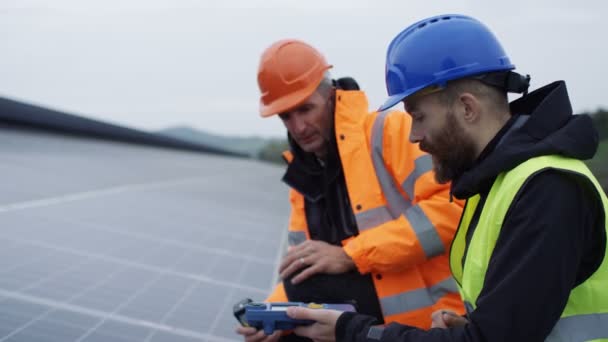 Técnicos 4K revisando los paneles en la instalación de energía solar
 - Imágenes, Vídeo
