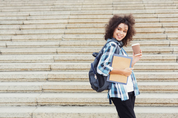 Студентка с рюкзаком и рабочими тетради на фоне конкретных шагов
 - Фото, изображение