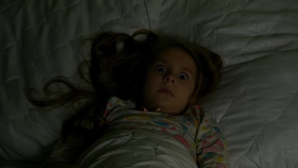 A lány feküdt az ágyban, a sötétben, és kezdődik a félelem - Felvétel, videó