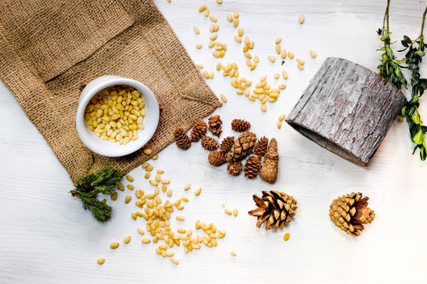 Pohled shora cedrové šišky, ve slupce a oloupané ořechy izolovaných na bílém pozadí - Fotografie, Obrázek