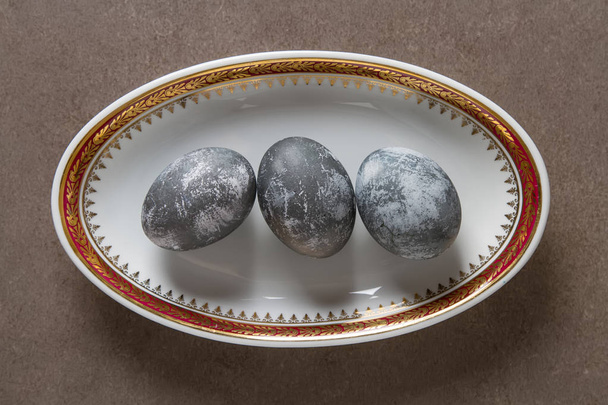 Easter composition with gray eggs on a colored background, space - Foto, afbeelding