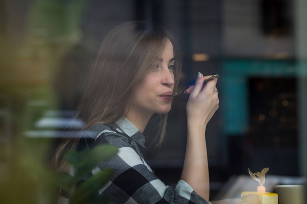 Beautiful girl is drinking tea in a cafe - Фото, зображення