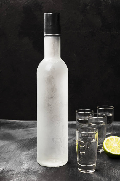 Cold vodka in shot glasses on a black background - Foto, Imagen