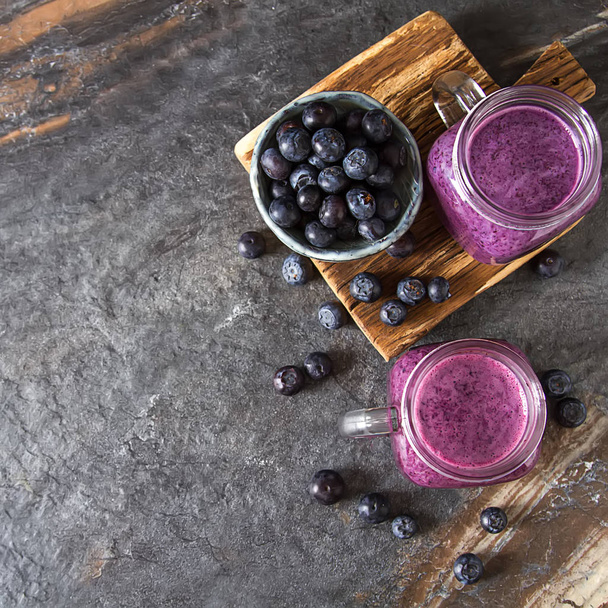 Fresh juicy blueberry smoothies in the glass. Simple background. - Foto, afbeelding