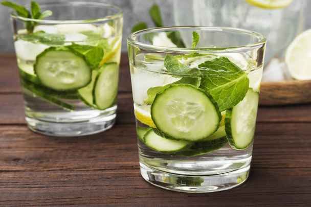 Detox drink with cucumber, lemon and mint in glasses on a wooden - Photo, image