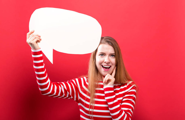 Young woman holding a speech bubble - Foto, afbeelding
