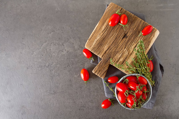 Small red cherry tomatoes in a ceramic vintage minsk. Dark backg - Фото, изображение