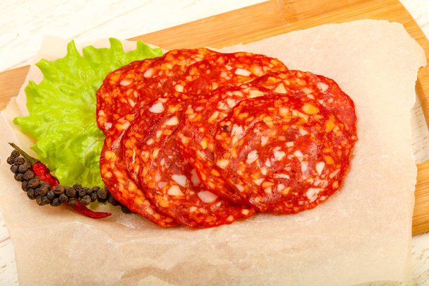 Sliced tasty Chorizo sausage over the wooden background - Photo, Image