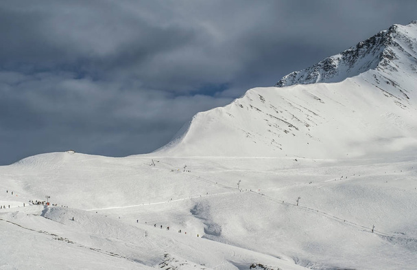 Una catena montuosa coperta da una neve bianca sotto un cielo blu scuro
 - Foto, immagini