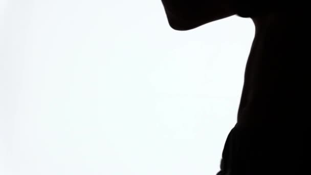 Silhouet van een sportieve jonge man tijdens de training op gevechten zonder regels. Knie stakingen. Beelden over de soorten vechtsport. Close-up van een profiel van een hand en een naakte torso met spieren. - Video