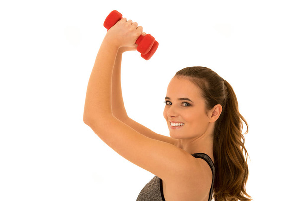 Beautiful young fit woman works out with dumbbells isolated over - Foto, imagen