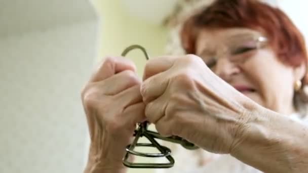 eine alte Frau löst ein Metallpuzzle auf, trainiert Gehirnaktivität - Filmmaterial, Video