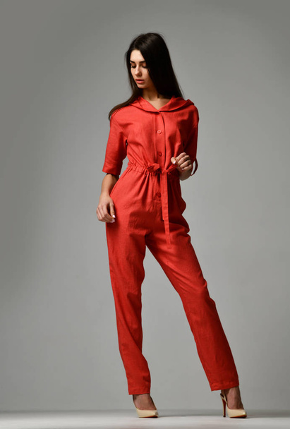 Young beautiful woman posing in new red fashion costume dress with pants and hood - Foto, Imagem
