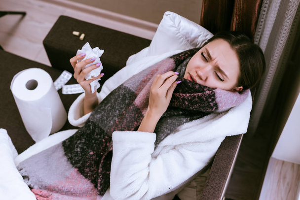 a sick woman lies on a bed and takes medication - Zdjęcie, obraz
