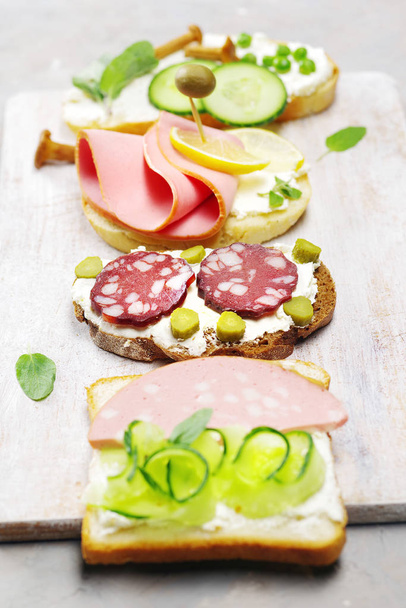 Sandwiches de una variedad de ingredientes en una superficie rústica ligera
.  - Foto, imagen