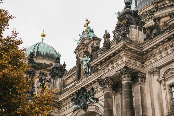 Берлинский собор называется Berliner Dom. Красивое старинное здание в стиле неоклассицизма и барокко с крестом и скульптурами
. - Фото, изображение
