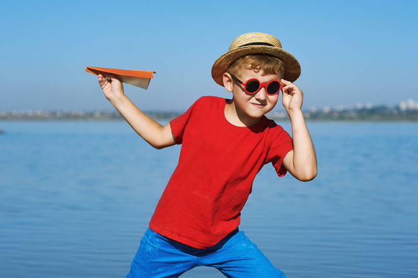 Un chico jugando con un avión de papel
 - Foto, Imagen