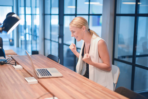 Boldog üzleti szőke lány használ egy laptop egy irodában - Fotó, kép