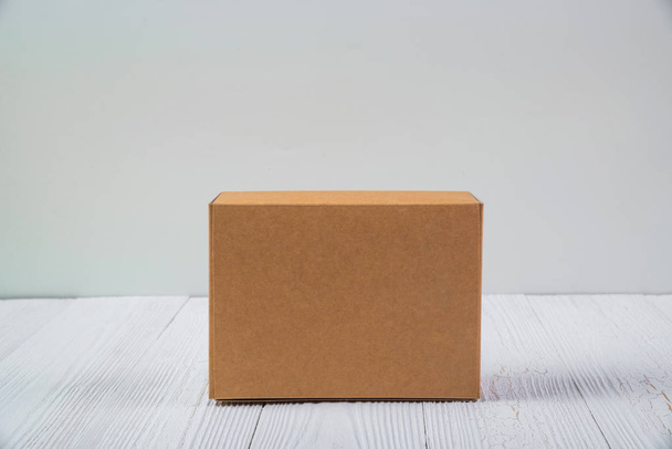 Pusty pakiet brązowy karton lub taca na jasny drewniany stół - Zdjęcie, obraz