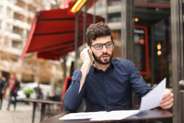 Emlakçı müşteri ile kafeterya masada telefonla konuşuyor - Fotoğraf, Görsel