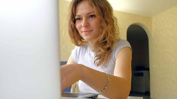 Nainen suunnittelija piirtää grafiikka tabletti. Nainen työskentelee kannettavan tietokoneen kanssa toimistossa kotona
 - Valokuva, kuva