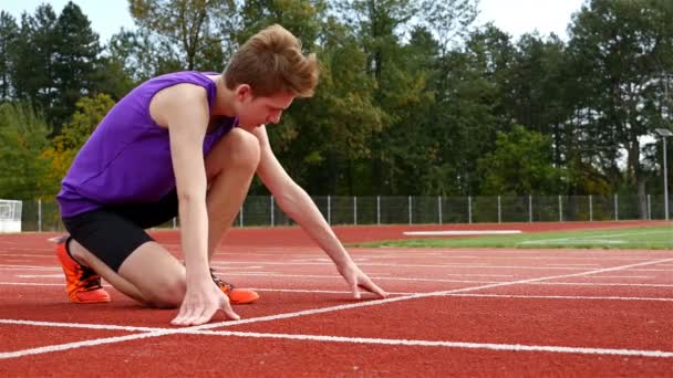 Track runner boy teenager preparing to run at starting line, 4k - Footage, Video