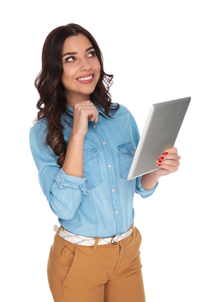 smiling casual woman holding tablet is dreaming - Photo, Image