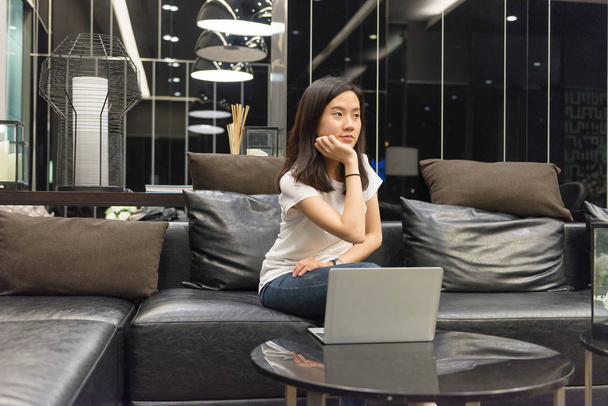 Mujer asiática estresada usando el ordenador portátil en la noche, independiente trabajando la
 - Foto, Imagen