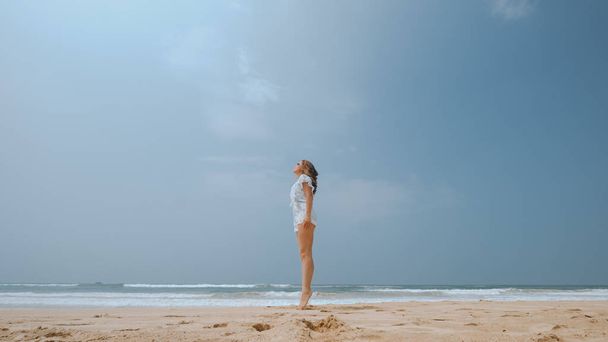 Girl jumping on the beach near the ocean - Zdjęcie, obraz