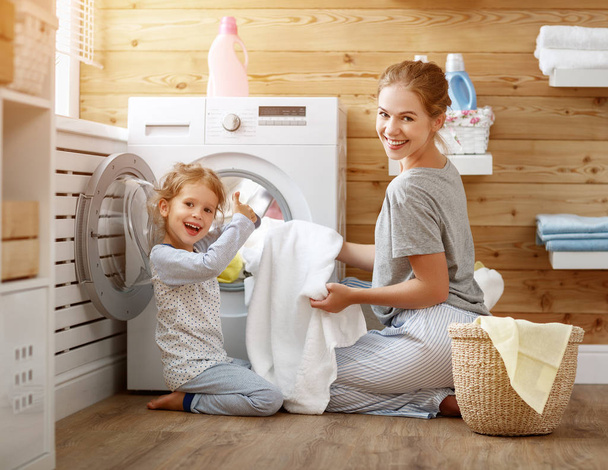 Onnellinen perhe äiti kotiäiti ja lapsi pyykissä pesu
 - Valokuva, kuva