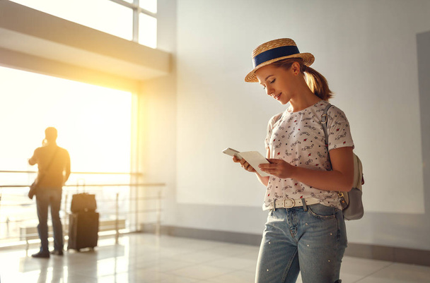 jeune femme attendant de voler à l'aéroport à la fenêtre avec des valises
 - Photo, image